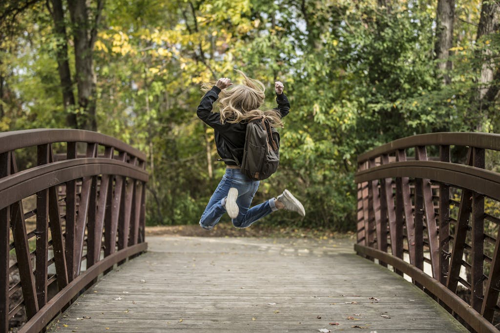 Girl Jumping on the Bridge Wearing Black Jacket depicting how a bridging loan works for property
