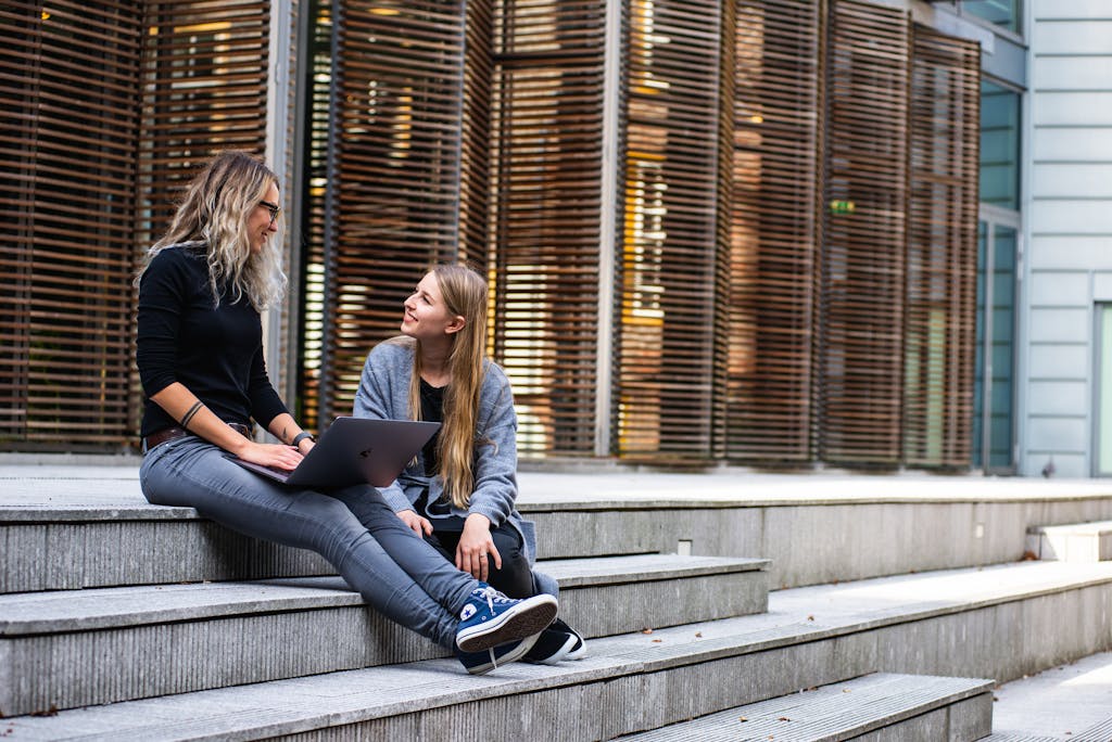 Two Women Having Conversation about HECS debt on Stairs