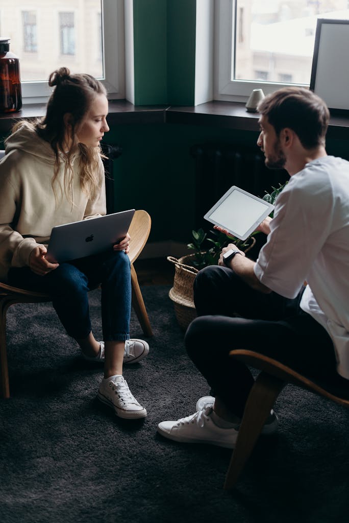 Photo of Couple talking about their home loan While Holding Laptop and Ipad