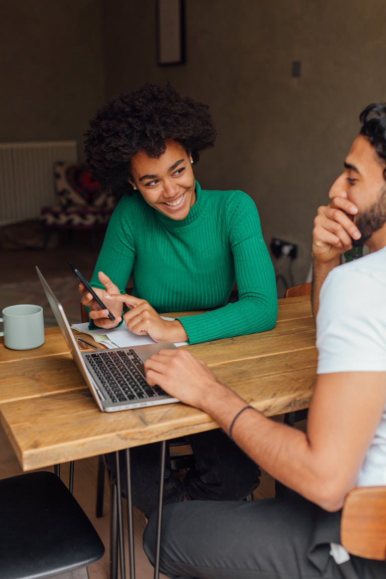 A Man and Woman Having Conversation about their home loan while Sitting Near the Wooden Table calling their Perth mortgage broker