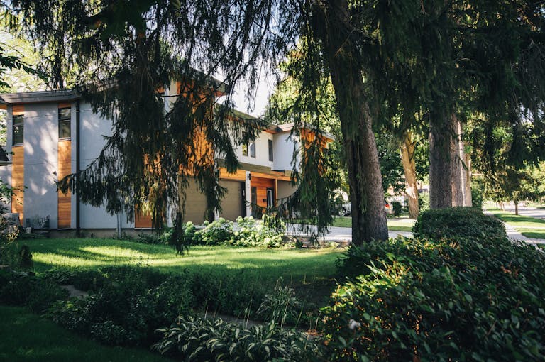 White Painted House Near Green Leafed Trees investment property finance