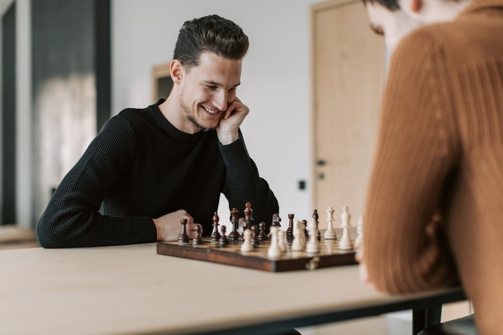 Two young men strategizing over a chess game in a modern indoor setting while discussing alternative lenders in Australia for home loans.
