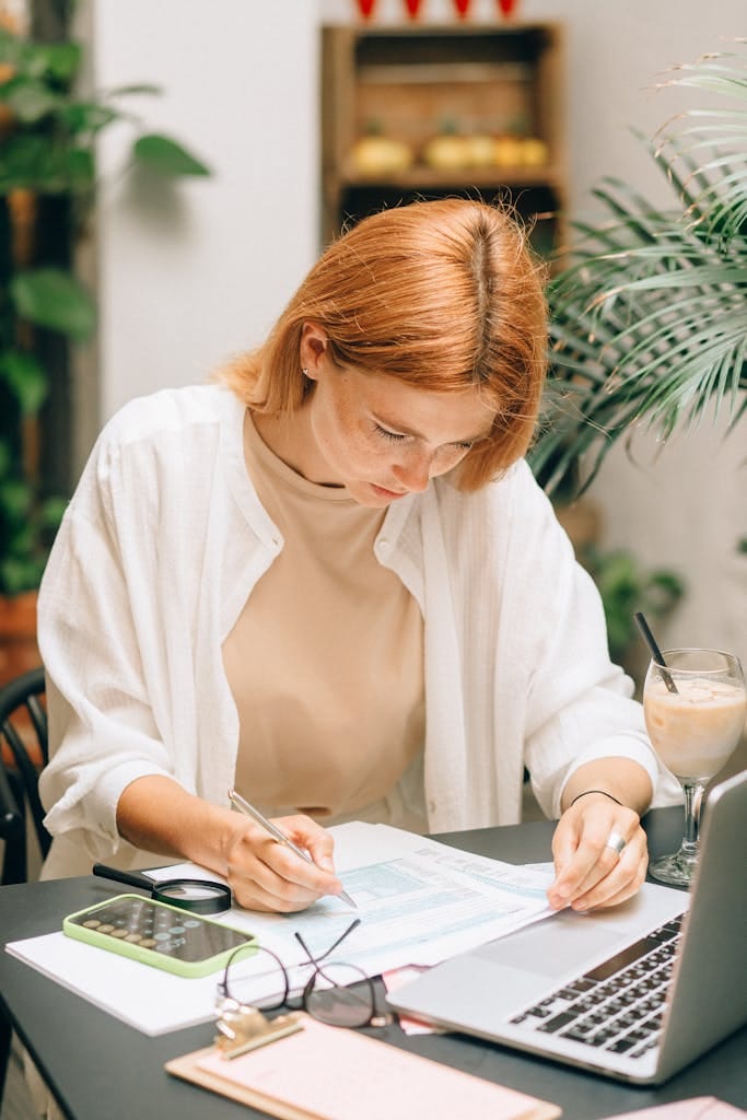 Woman analyzing financial documents using laptop and looking for debt consolidation by refinancing her home loan.