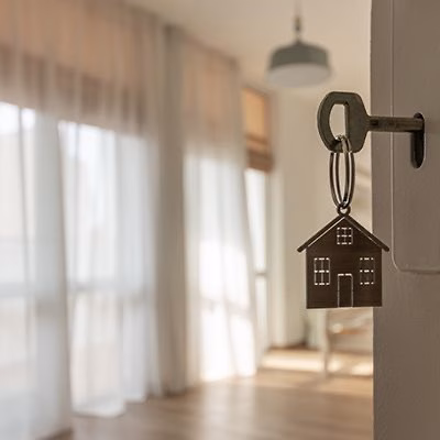 a key opening a door with a house keyring, Keystart property price limits and sheer curtains in a new modern home representing home ownership for first home buyers in Perth
