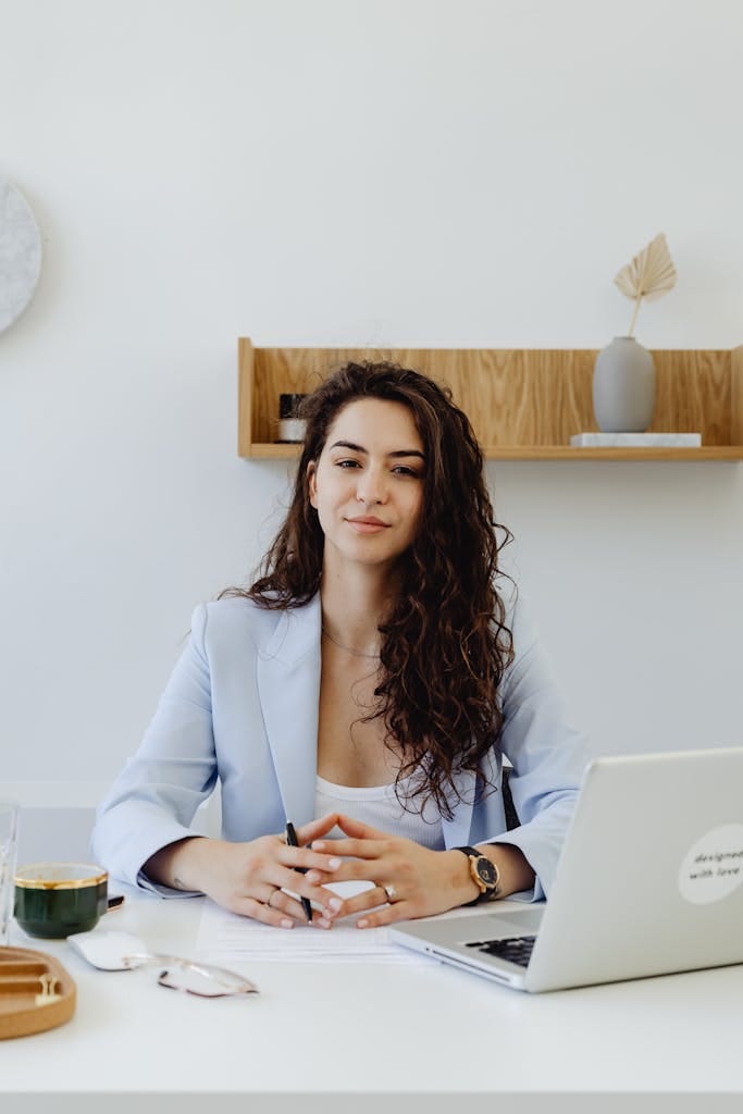 Portrait of a confident businesswoman sitting at a desk with a laptop in a modern office looking for self employed loan with perth mortgage broker.
