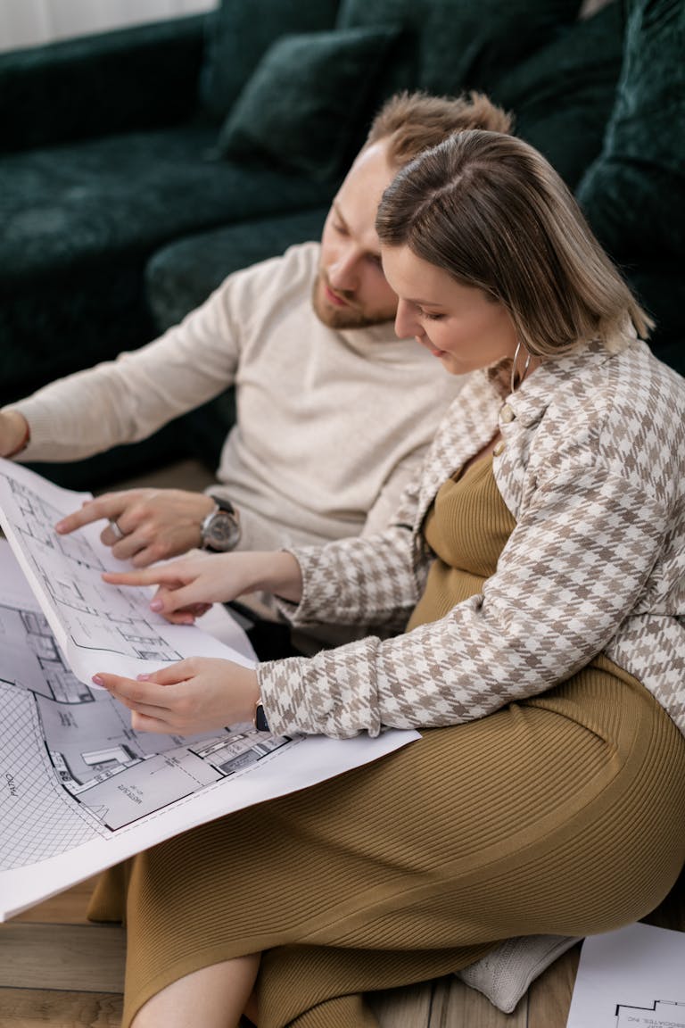 Couple examining architectural blueprints, symbolising home planning or buying process in the perth property market