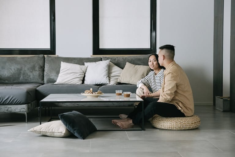 A couple enjoying a serene moment in a stylish Scandinavian-inspired living room wondering if perth house prices will drop soon.