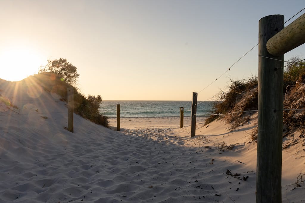 Tranquil pathway leading to Cottesloe Beach at sunset with soft sand and ocean view mortgage broker perth