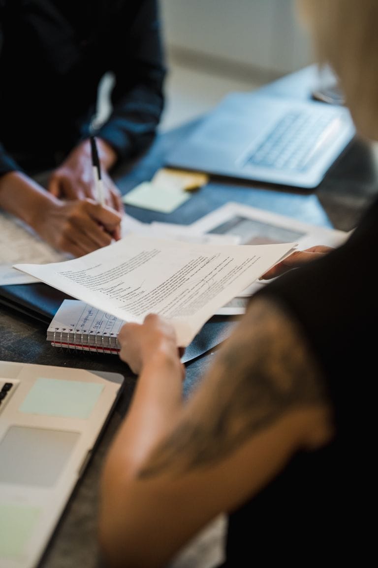 Two professionals collaborate on document reviews in a modern office after commercial loan approval.